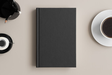 Black book mockup with a coffee and workspace accessories on the beige table.