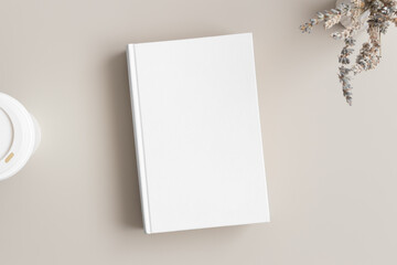 White book mockup with a lavender and a coffee paper cup on the beige table.