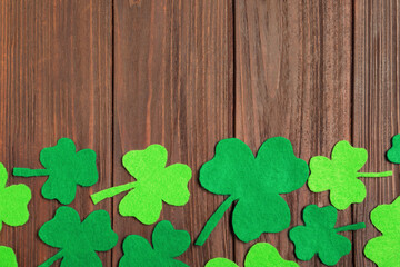 Flat lay composition with clover leaves on wooden background, space for text. St. Patrick's Day celebration