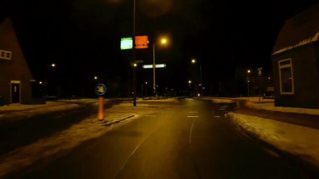 Netherlands - 10 februari 2021, Hilversum: Night-time curfew during corona time POV driving through empty streets timelapse