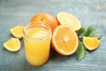 Delicious orange juice and fresh fruits on light blue wooden table