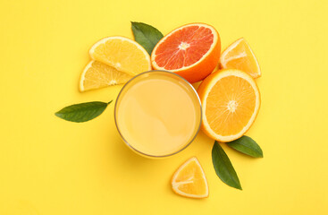 Delicious orange juice and fresh fruits on yellow background, flat lay
