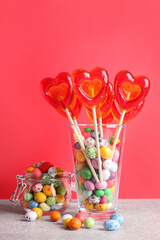 Delicious heart shaped lollipops and dragees on table