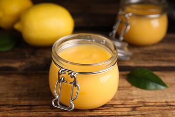 Delicious lemon curd in glass jar on wooden table