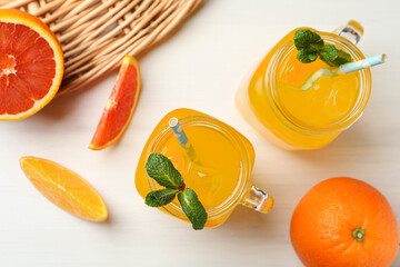 Delicious orange soda water on white wooden table, flat lay