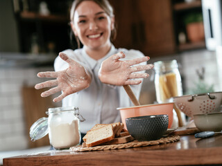 Portrait of young woman in the kitchen. Happy smiling woman baking at home.