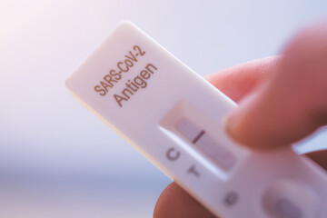 Express corona test at home: Close up of fingers holding a negative covid antigen test