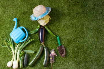 Concepto de un muñeco hecho de verduras y vegetales con un sombrero y una regadera de hortelano...