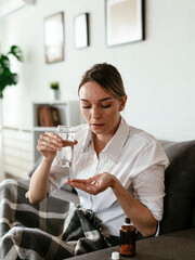Young woman sick in bed. .Woman drinking medicine, having stomach pain