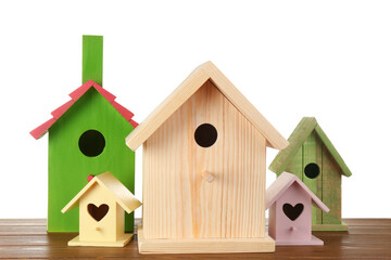 Obraz na płótnie Canvas Many different bird houses on wooden table against white background