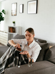 Young woman sick in bed. .Woman drinking medicine, having stomach pain