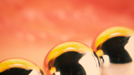 Three metal balls on pink, blurred background.