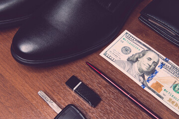 flash drive, pen, dollars, wallet, leather shoes on a wooden background