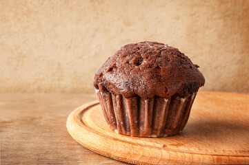 Chocolate muffin on a wooden table. Fresh bakery.