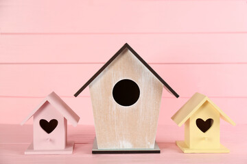 Obraz na płótnie Canvas Collection of handmade bird houses on pink wooden table