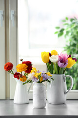Different beautiful spring flowers on window sill