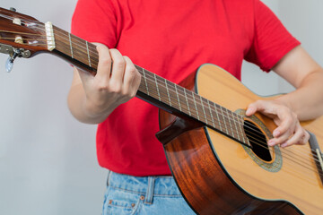 Female model holding a wooden guitar