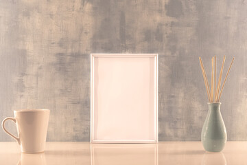 Modèle de cadre photo blanc avec espace vide pour logos, inscription publicitaire. Cadre en mode portrait sur un espace de travail avec une tasse et des bâtons d'encens.	