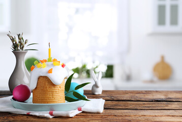 Delicious Easter cake and painted eggs on wooden table indoors. Space for text