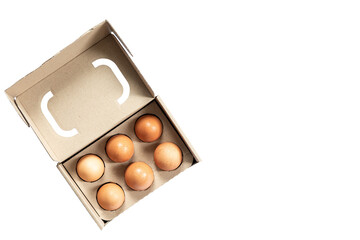 Close-up view of raw chicken eggs in egg box on white wooden background