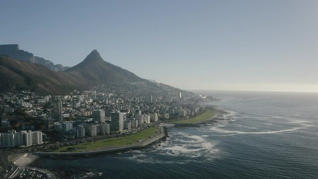 Aerial view of Cape Town, South Africa, with Green Point and Sea Point, Table Mountain, Lion's Head, Signal Hill and Devil's Peak on a bright and sunny day filmed in 4k with a drone