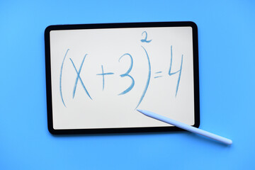 Tablet ipad with the mathematical equation inscription with apple Pencil and on blue background