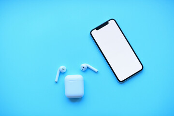 Mockup . iphone and air pods on blue background