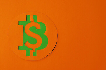 Bitcoin is connected to the dollar on an orange background with a copy space. Conceptual collage about cryptocurrency in the power of minimalism. High quality photo