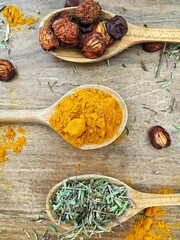 Three wooden spoons with seasoninf on the wooden table