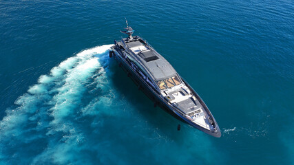 Aerial drone photo of modern yacht preparing to speed in Mediterranean port with deep blue sea