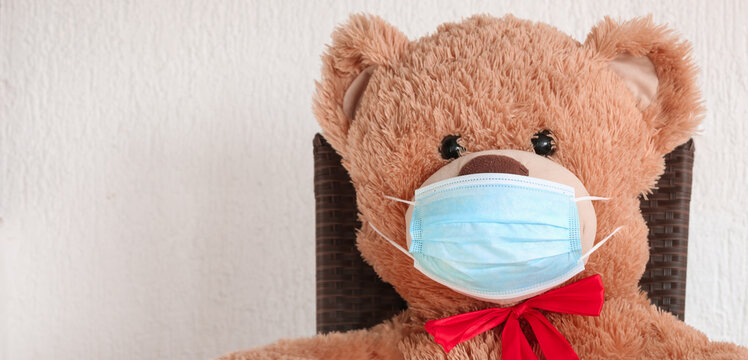Teddy Bear wearing medical mask to emphasize the social aspect of self isolation and loneliness that happens when one is alone, lonely teddy bear. Panorama coronavirus covid-19 global pandemic Banner