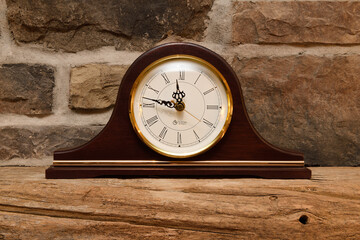 Antique mantelpiece clock on reclaimed barn beam over stone fireplace