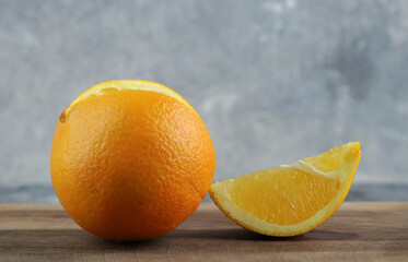Whole and sliced orange on marble background