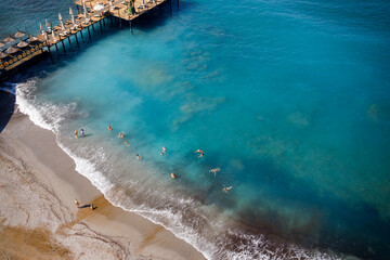 Aerial view of the beach and the mediterranean sea, beautiful clear sea water on a warm sunny day. The concept of rest in a warm country