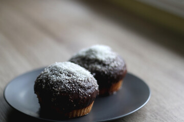 Two large homemade muffins with chocolate and coconut topping. Selective focus.