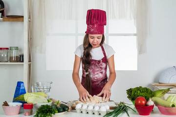 happy child wear cook uniform. chef girl in hat and apron. kid cooking food in kitchen. choosing a career. little helper knead dough. culinary and cuisine. happy childhood. chef ready to cook