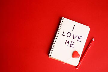 A notebook with a written phrase I love myself on red background. Concept mental health journaling,...