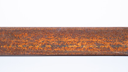 The rusted metal rod is full of the surface. Dirty iron rod placed on the floor and white background.