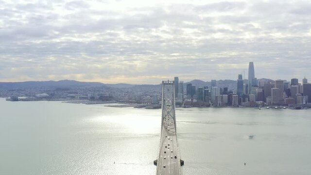 Aerial: people driving over the bridge towards the city. drone view