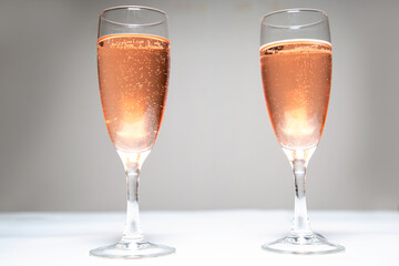 Two glasses of pink champagne on the table. Black-white background. Champagne for the holiday