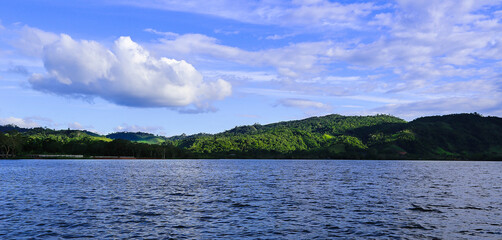 Huallaga river of the Peruvian high jungle. River among vegetation with light blue sky and white clouds.