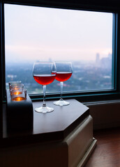 Wine glassed and city view from hotel window