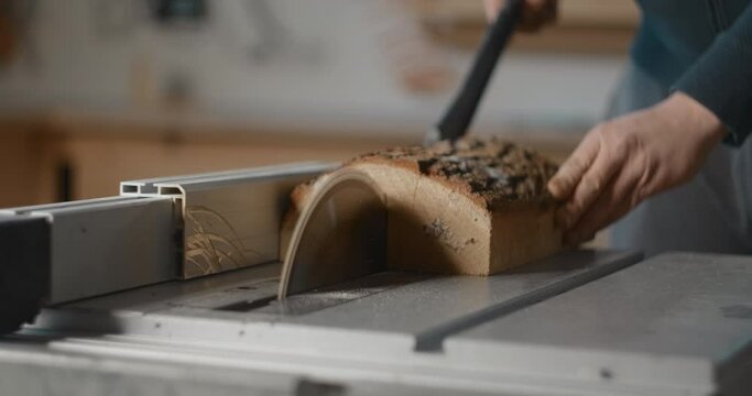 Carpenter saws logs on a circular saw in his workshop, making of the planks, slow motion carpentry, manufacture of products from timber, 4k DCI 60p Prores 422 HQ 10 bit