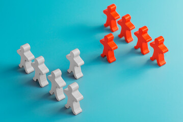 Two groups of wooden figures are standing in front of each other.  Two groups of toy people in the discussion. Conflict of interest. Business competition. Candidates political debate