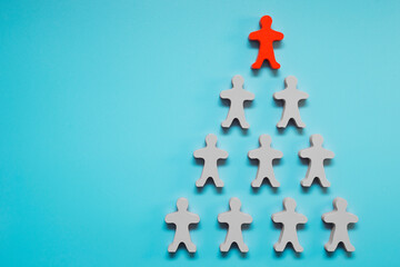 Team of toy people on blue background. The concept of human resources and corporate hierarchy - the recruiter is a complete team with one leader
