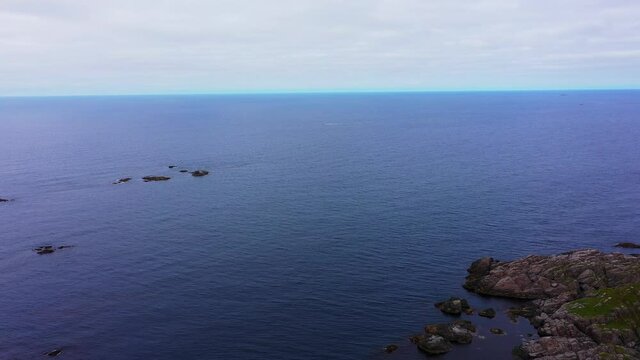 Aerial view of a boat driving on the coast of Sto, Vesteralen, Norway - pan, drone shot