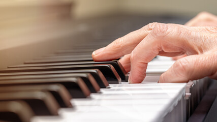 Fototapeta na wymiar Adult Hand Practicing Playing Piano