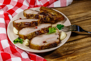 Baked pork belly in a plate on wooden table