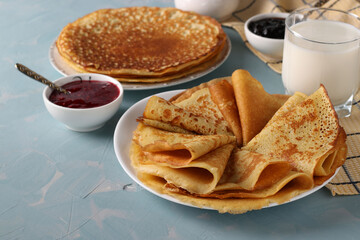 Homemade thin pancakes made from cornmeal, eggs and milk on light blue background