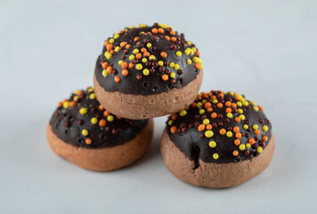 Chocolate cookies decorated with candies on white background